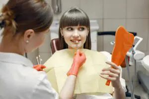 Woman choosing the shade of teeth for her dental implants with her dentist Photo by Gustavo Fring: https://www.pexels.com/photo/a-woman-on-a-dental-clinic-4971503/ 