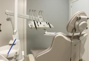 https://pixabay.com/photos/dental-clinic-orthodontics-teeth-2450751/ Image of a dentist chair with dental tools. 